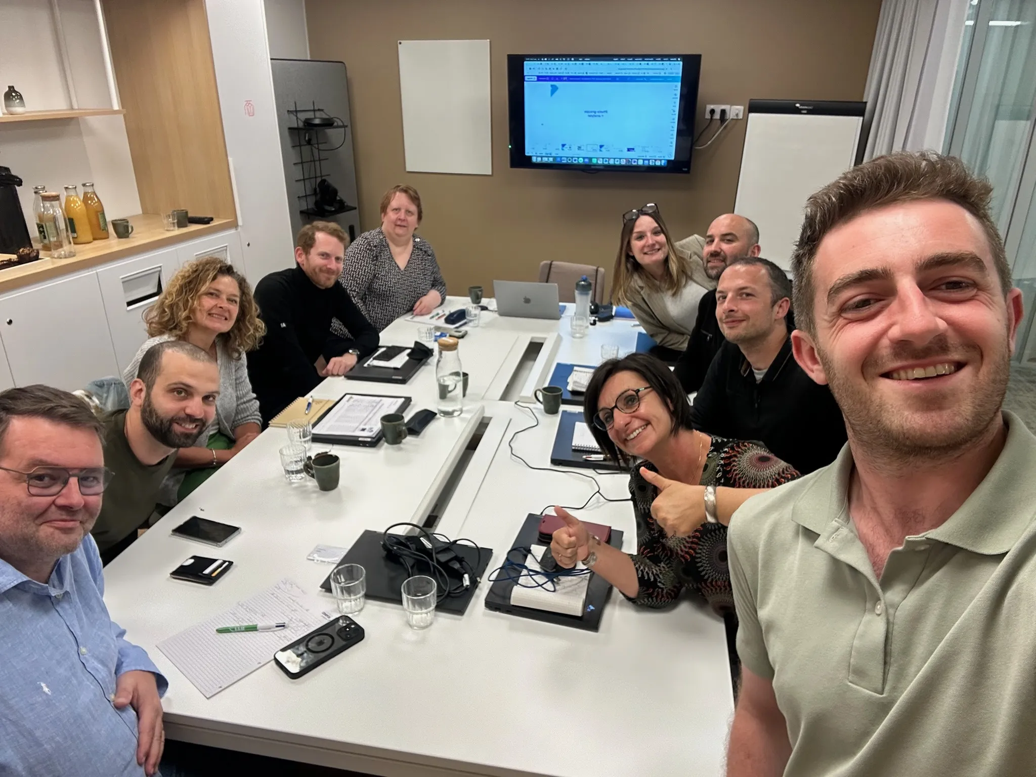 Équipe souriante en salle de formation IA - 9 collaborateurs